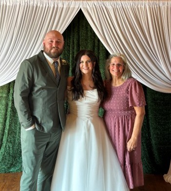 Beth with a couple on their wedding day